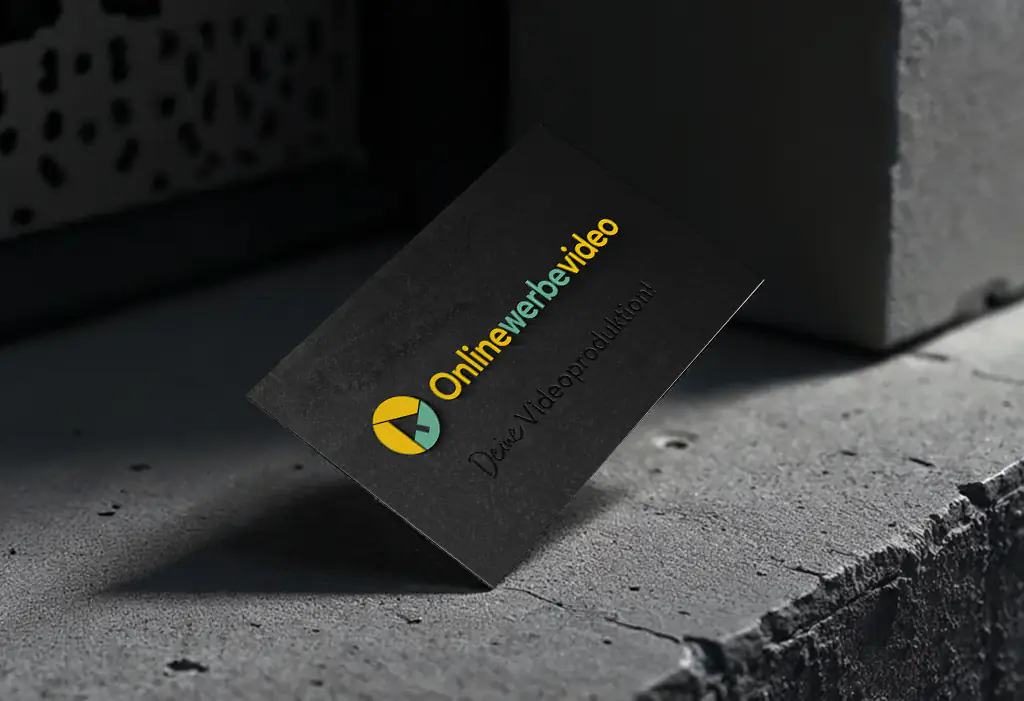 Mockup der dunklen Visitenkarten-Vorderseite von Onlinewerbevideo auf einer grauen Steinoberfläche. Ein Design-Projekt von foxdot.me.